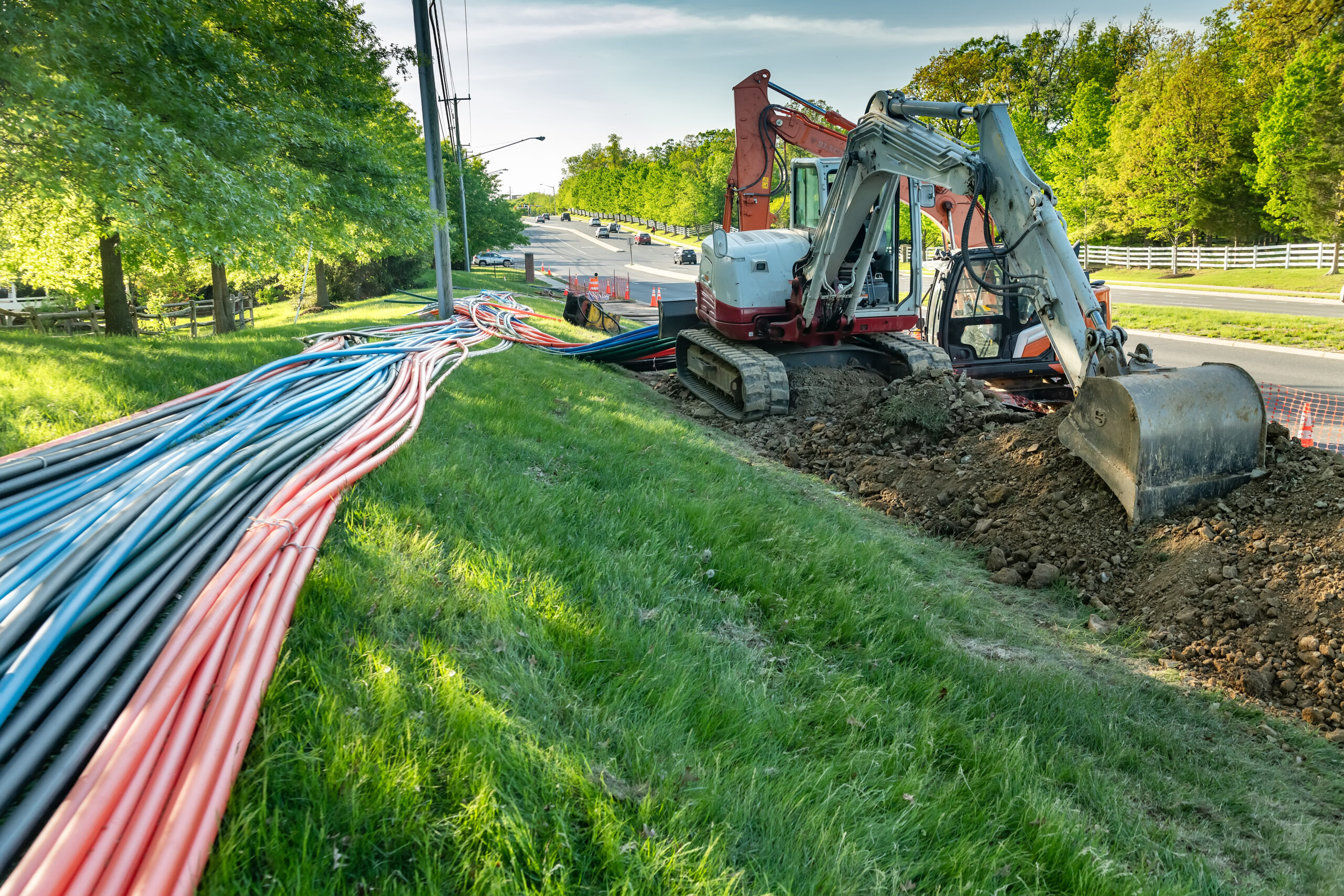 Fleet vehicle rental for telecom - image shows excavator and drilling equipment for laying broadband internet cables underground.