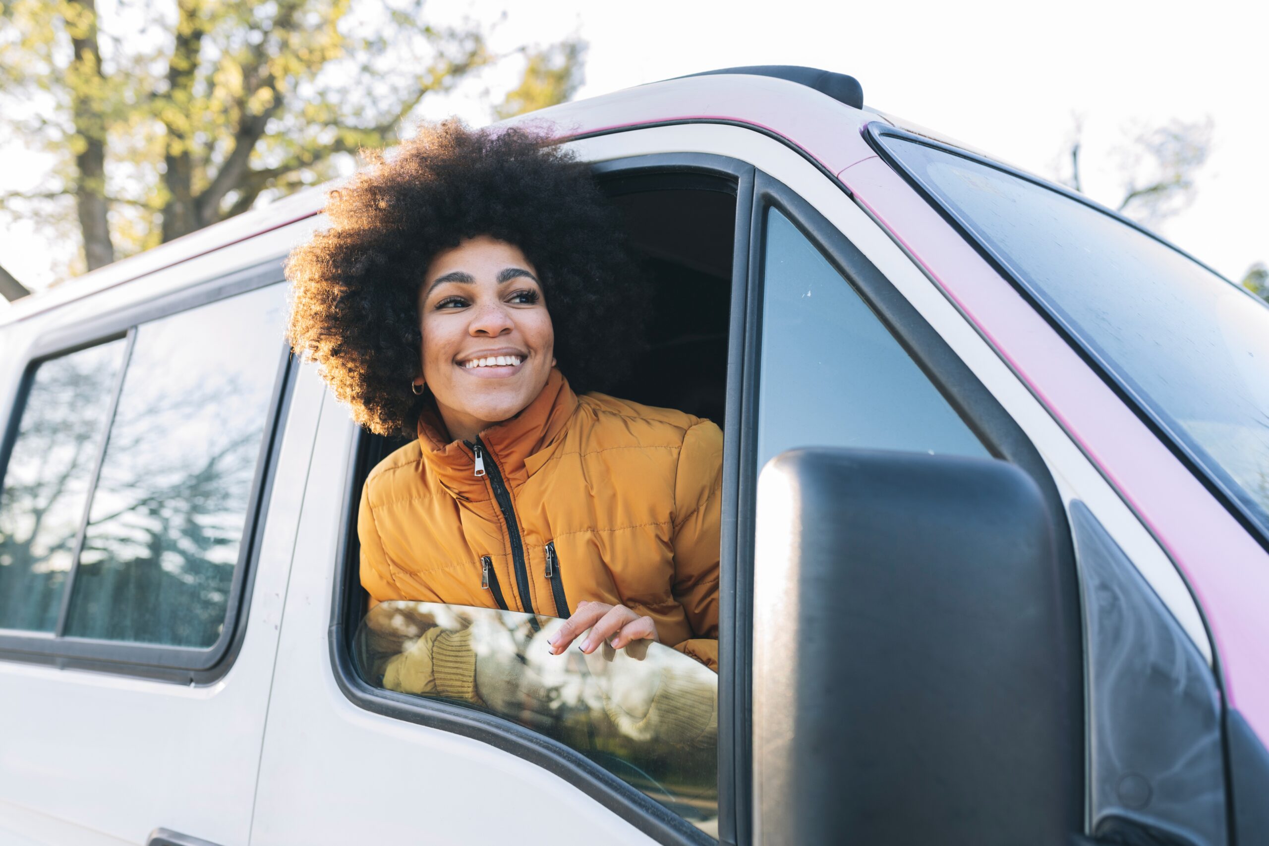 Long term van rentals - image shows smiling woman in van on road trip