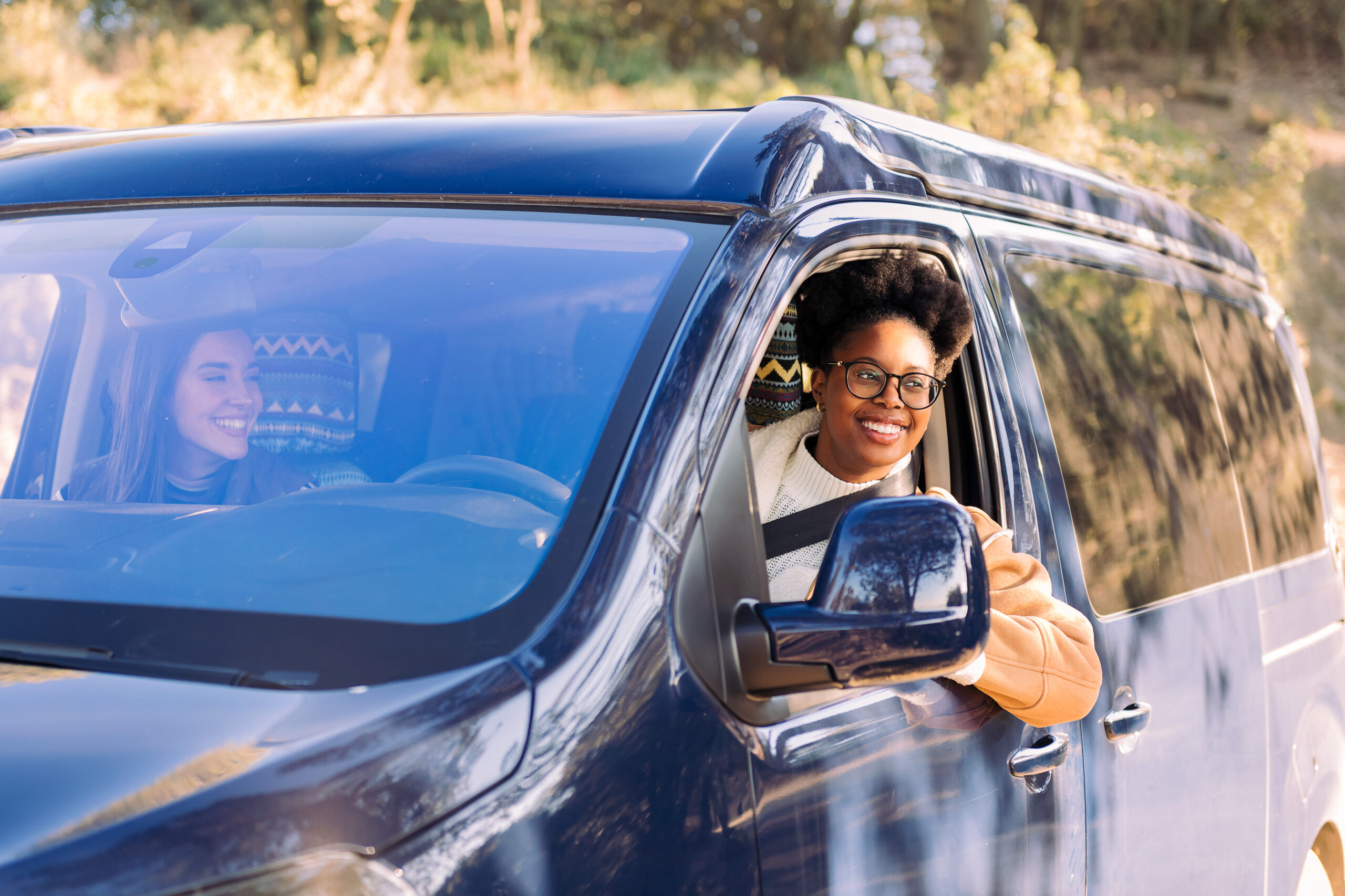 Long term van rentals - image shows smiling woman in van on a road trip