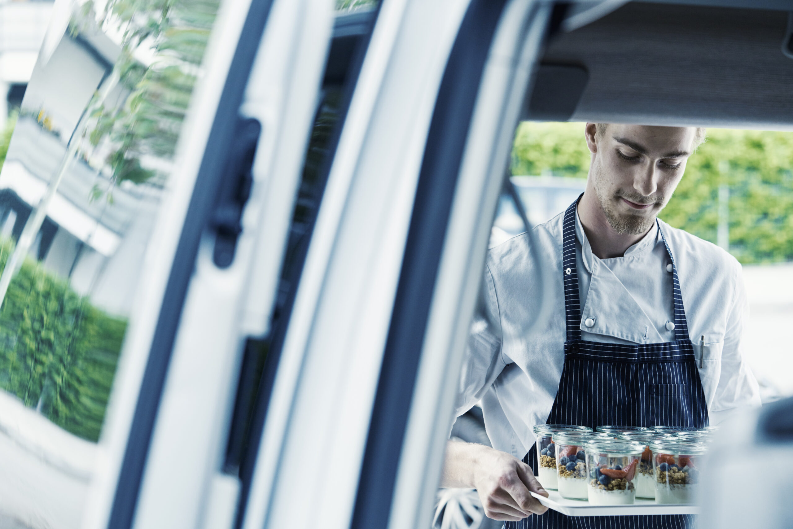 Business van rental solutions for integrated FM - image shows catering employee taking supplies out of van